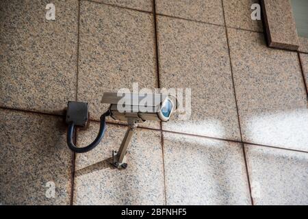 Urban security camera on the wall Stock Photo