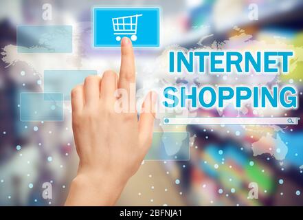 Woman pushing shopping cart button of internet store on virtual screen Stock Photo