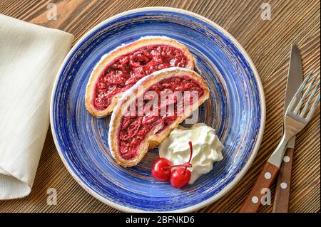 Slices of cherry strudel with whipped cream Stock Photo