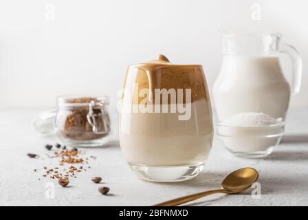 Homemade Dalgona coffee in glass with ingredients. Recipe popular Korean drink latte with foam of instant coffee. Stock Photo