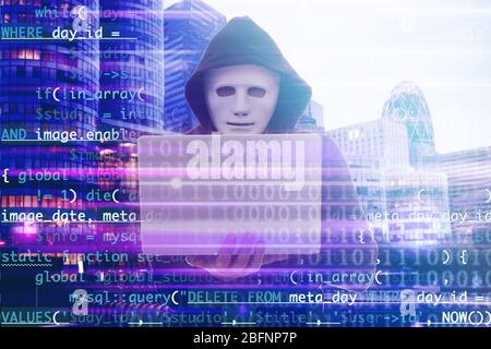 Double exposure of hacker using laptop, code and cityscape view. Concept of cyber attack and security Stock Photo