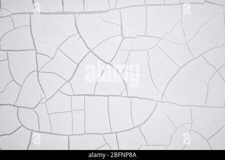 White old crackled paint on a wall. Crackle texture. Crackling abstract background. Stock Photo