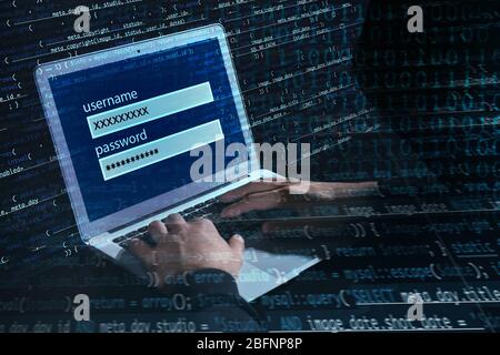 Man hacking account on laptop in darkness. Concept of cyber attack and security Stock Photo