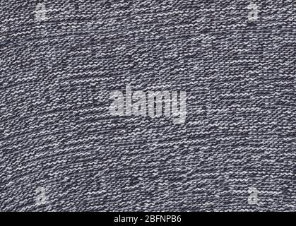 Texture of knitted fabric. Cold weather background. Warm black and white wool sweater texture. Knitted fabric background. Stock Photo