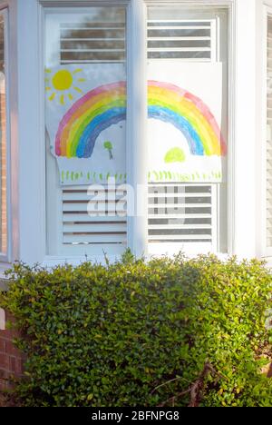 Colourful hand drawn rainbows and heartfelt messages to NHS workers displayed in windows of homes. Stock Photo