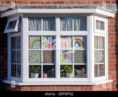 Colourful hand drawn rainbows and heartfelt messages to NHS workers displayed in windows of homes. Stock Photo