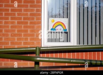 Colourful hand drawn rainbows and heartfelt messages to NHS workers displayed in windows of homes. Stock Photo