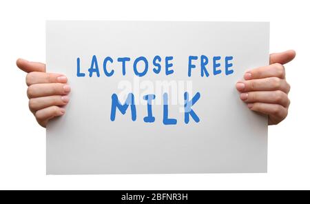 Health care concept. Female hands holding banner with text LACTOSE FREE MILK on white background Stock Photo