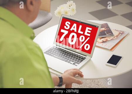 Sale concept. Senior man using laptop for internet online shopping at home Stock Photo
