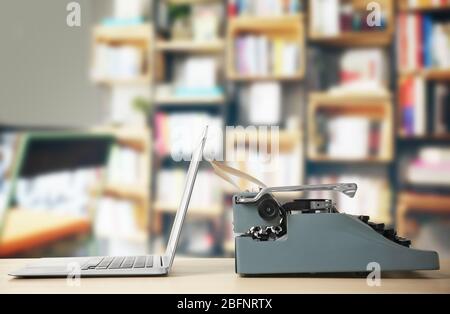 Old typewriter and laptop on table at library Stock Photo