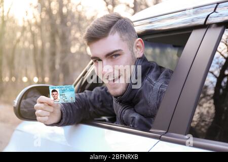 Woman with driving license in car Stock Photo