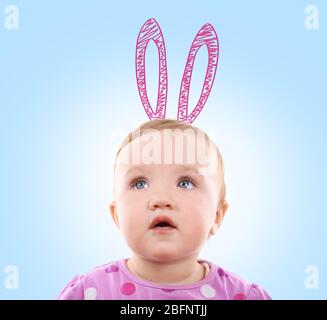 Cute little girl with drawn bunny ears on color background Stock Photo