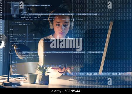 Program development concept. Young woman listening to music while working with laptop Stock Photo