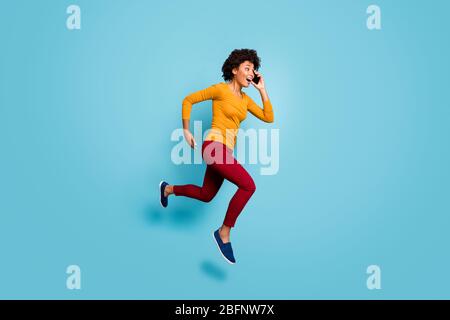 Full length body size view of nice attractive cheerful motivated energetic wavy-haired girl jumping talking on cell running fast hurry rush isolated Stock Photo