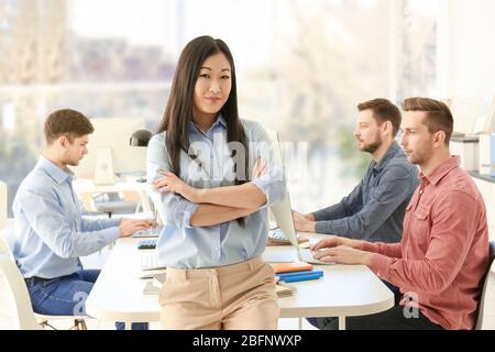 Young female programmer with colleagues in office Stock Photo