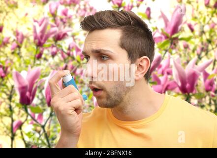 Young man using asthma inhaler outdoor Stock Photo
