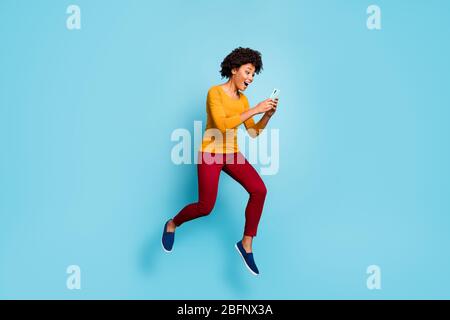Full length body size view of her she nice attractive positive glad cheerful cheery wavy-haired girl jumping running using cell having fun isolated on Stock Photo