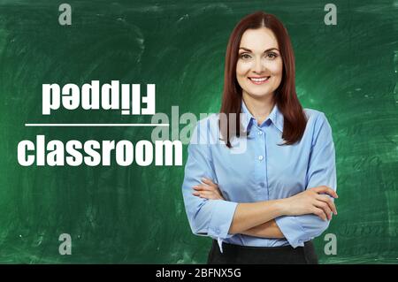 Flipped classroom concept. Teacher on blackboard background Stock Photo