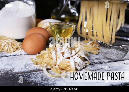 Raw homemade pasta and ingredients on wooden table Stock Photo