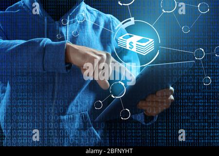 Hacker working with tablet against dark background. Threat of cyber attack and financial fraud Stock Photo