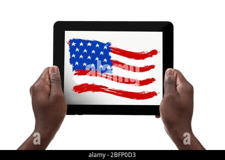 African-American man holding tablet with USA flag against white background Stock Photo