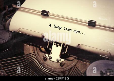 Sheet of paper with text 'A long time ago' in old typewrite, closeup Stock Photo