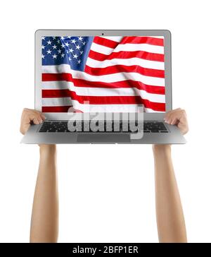 Young woman holding laptop with American flag on screen against white background Stock Photo