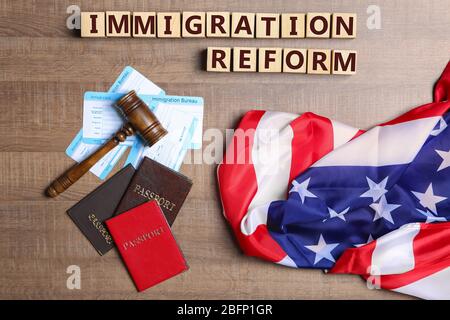 Cubes with text IMMIGRATION REFORM, judge's gavel and American flag on table Stock Photo