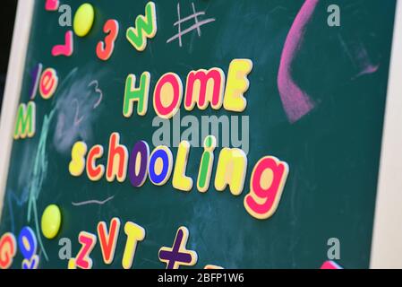 A colourful ‘Home Schooling’ written on a blackboard in magnetic letters. Stock Photo