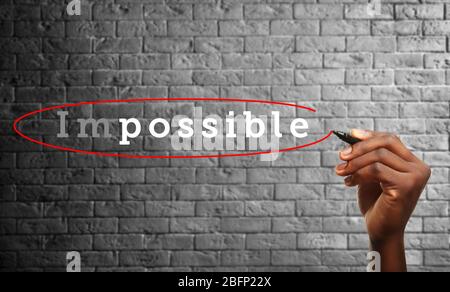 Human hand turning word impossible into possible Stock Photo