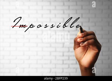 Human hand turning word impossible into possible Stock Photo