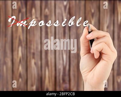 Human hand turning word impossible into possible Stock Photo