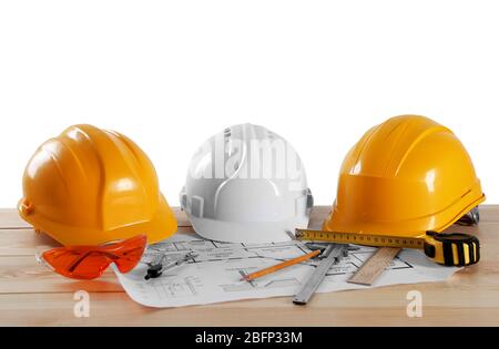 Construction drawings with tools on wooden table isolated on white background Stock Photo