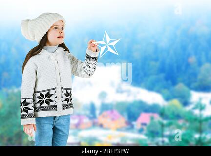 Little girl in a trendy knitted clothes on blurred landscape background Stock Photo