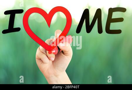 Love yourself concept. Hand writing I Love Me on transparent whiteboard on natural background Stock Photo