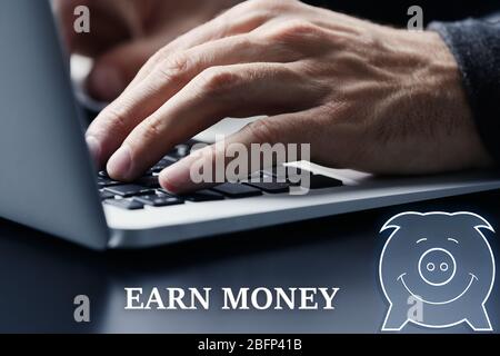 Male hands typing on laptop keyboard at table closeup. Earn money concept Stock Photo