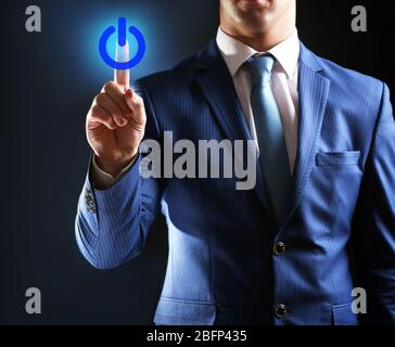 Finger press power button on virtual touch screen, modern technology concept Stock Photo