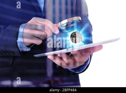 Businessman holding magnifying glass and digital tablet, isolated on white, double exposition Stock Photo