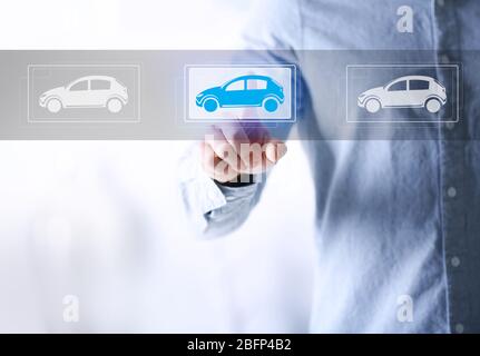Young man touching icon of car on virtual screen Stock Photo