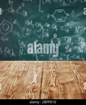 Wooden table on blackboard background. School concept. Stock Photo