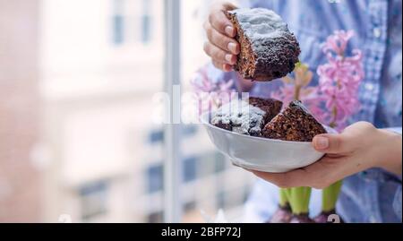 Pie in female hands. Flowers, pastries and a girl near the window. Soft focus. copy space. Stock Photo