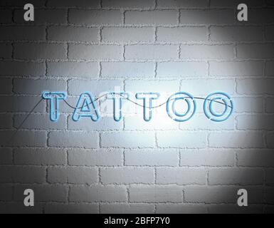 Sign Tattoo on white brick wall background Stock Photo