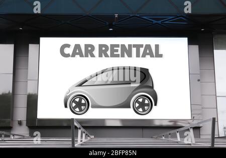 Digital advertisement display with text car rental on building. Stock Photo