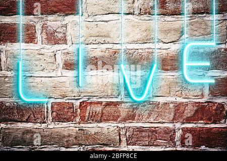 Neon text live on brick wall background. Stock Photo