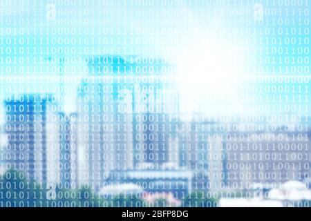 Binary code on blurred cityscape background. Stock Photo