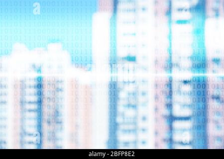 Binary code on blurred cityscape background. Stock Photo