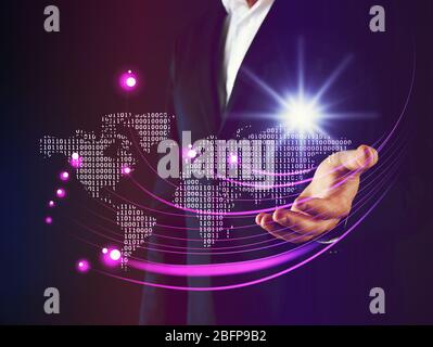 Businessman working with virtual touchscreen. World map and binary code on digital display. Technology concept. Stock Photo