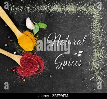 Composition of different spices on dark background. Text Natural Spices. Stock Photo