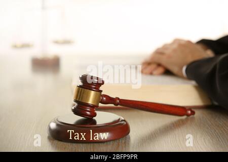 Wooden judges gavel on wooden table, close up. Tax law concept Stock Photo