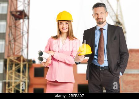 Two construction engineers on blurred construction of residential house Stock Photo